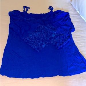 Off the shoulder, loose fitting blue top.